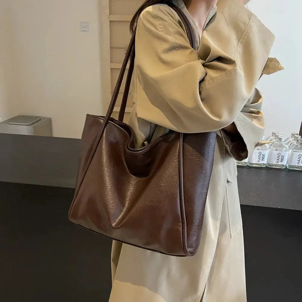 Brown large faux leather minimalist commuter tote bag with long handles for easy carrying