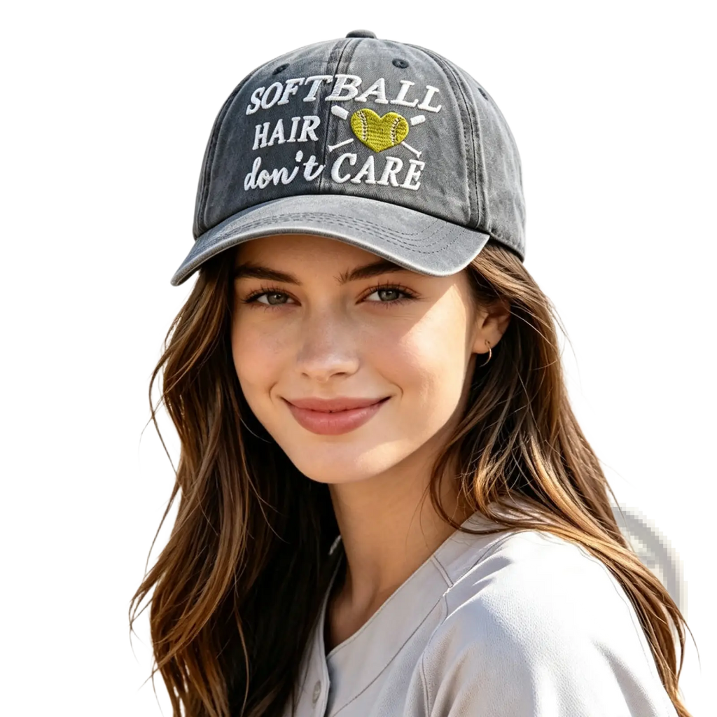 A faded gray distressed softball hair dont care cap with white embroidered text and a yellow heart-shaped softball design