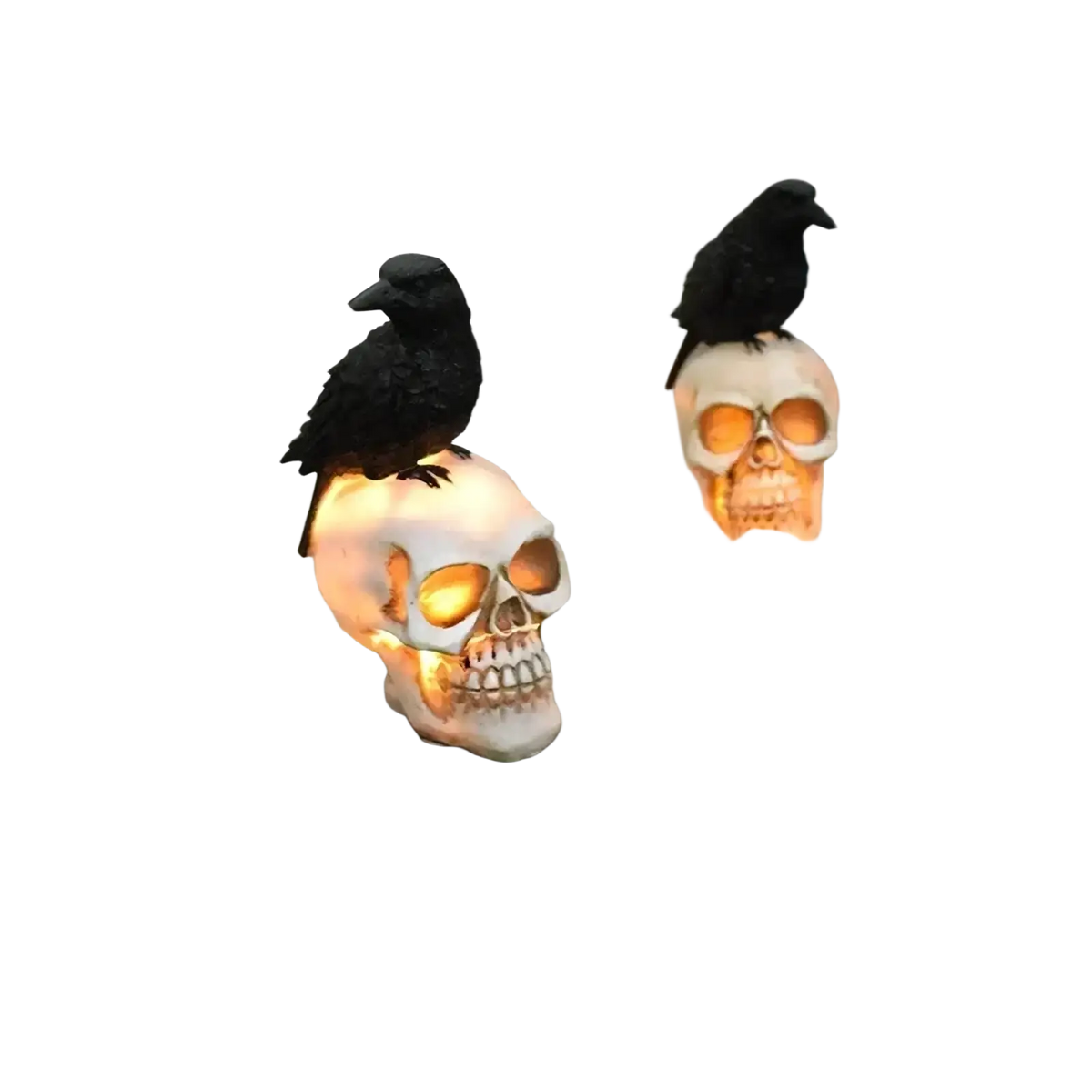 Two illuminated black crow figurines atop solar skull garden light ornaments for outdoor decoration