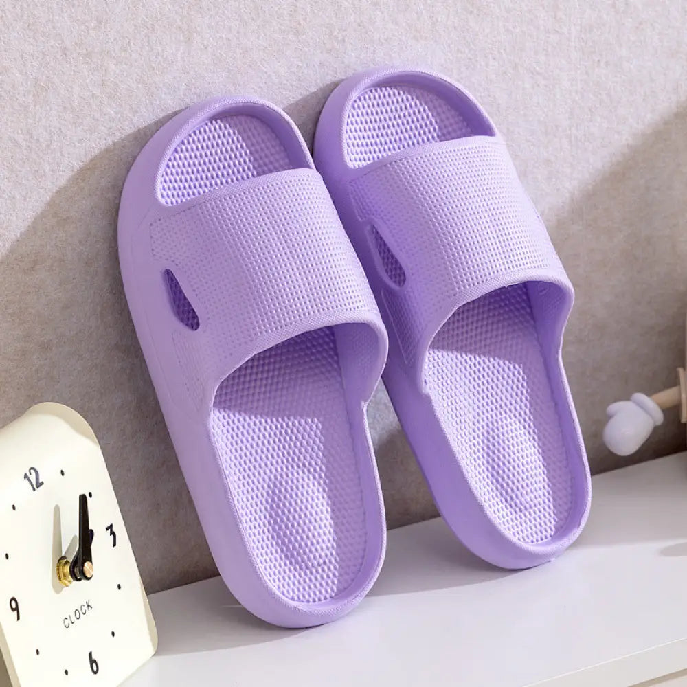 Pair of lavender textured plastic slide sandals with thick sole non slip cushioned design for home use