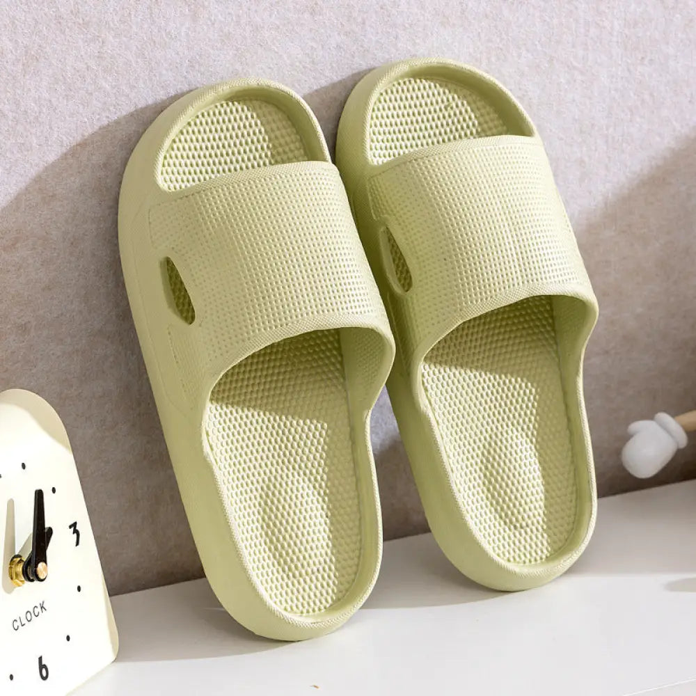 Pair of pale green textured rubber slide sandals with breathable mesh and side cutouts for non slip cushioned comfort