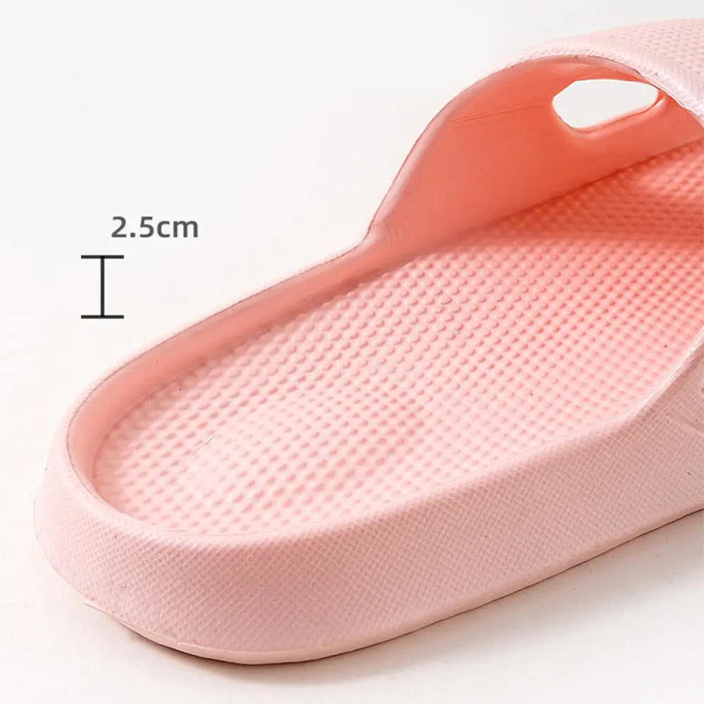 Pink rubber slide sandal with thick non slip cushioned sole and textured perforated open toe design for home use