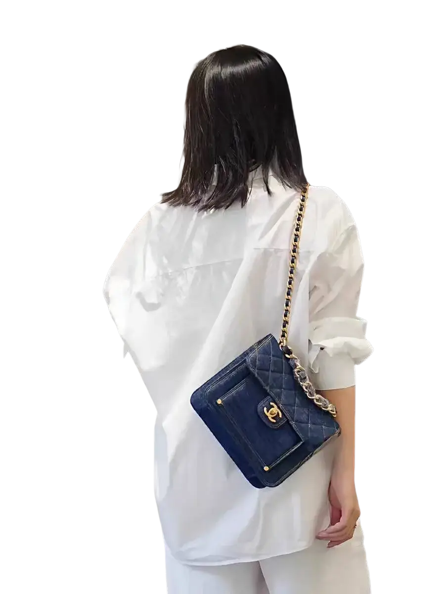 Navy blue quilted leather Chanel handbag with gold-tone hardware and chain strap paired with solid white basic shirt