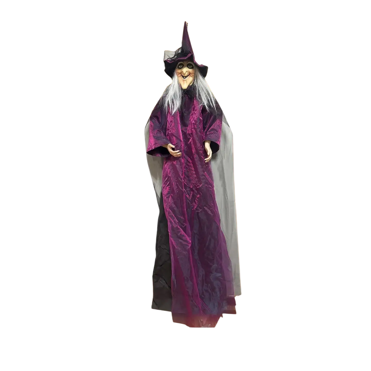 A sound activated halloween witch prop with a tall purple robe and pointed hat as a porch centerpiece