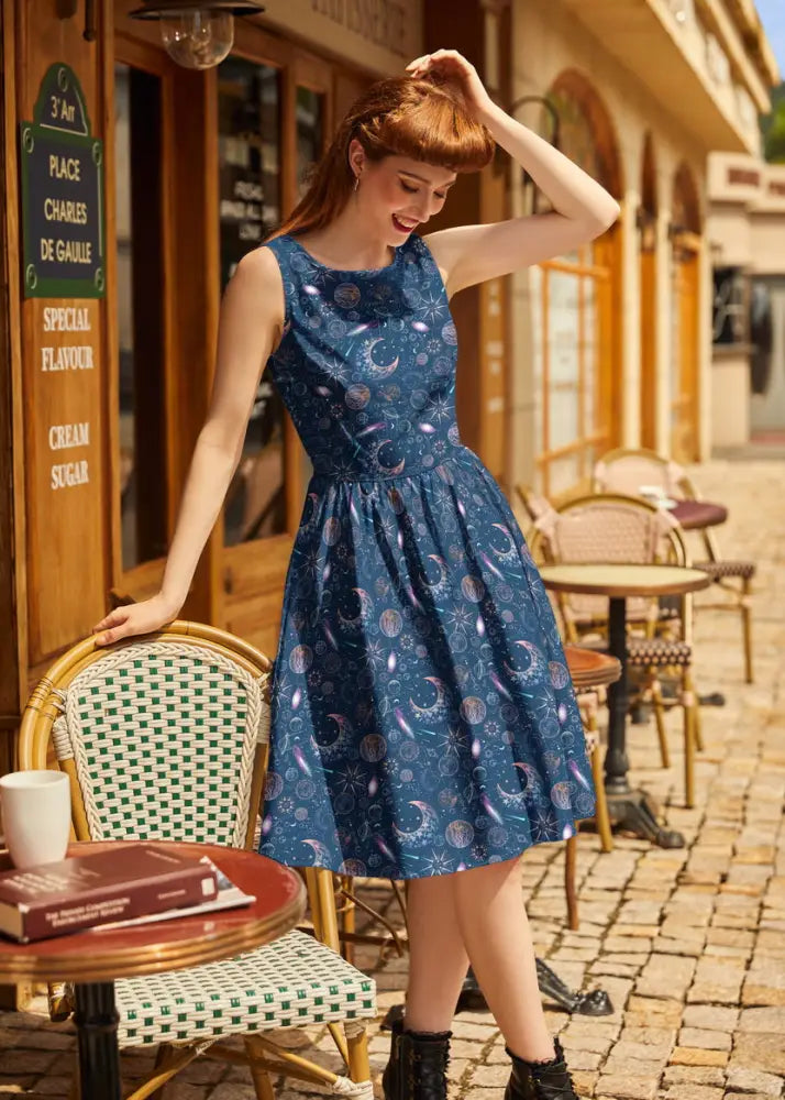 A navy celestial 1950s vintage sleeveless cotton a-line dress with pockets featuring moons stars and planets pattern