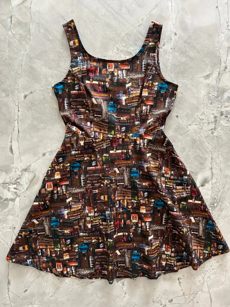 Sleeveless a-line skater dress in dark brown with a colorful bookshelf print and functional pockets