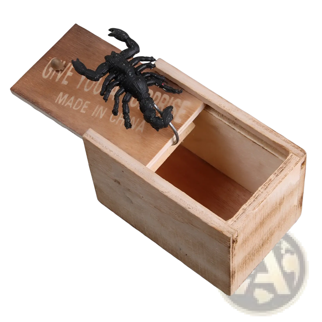 Black plastic scorpion perched on light brown wooden prank scare box with engraved text for trick surprise toy