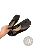 Black leather moccasin-style flats with distinctive split toe seam and mid heel in tabi horseshoe design