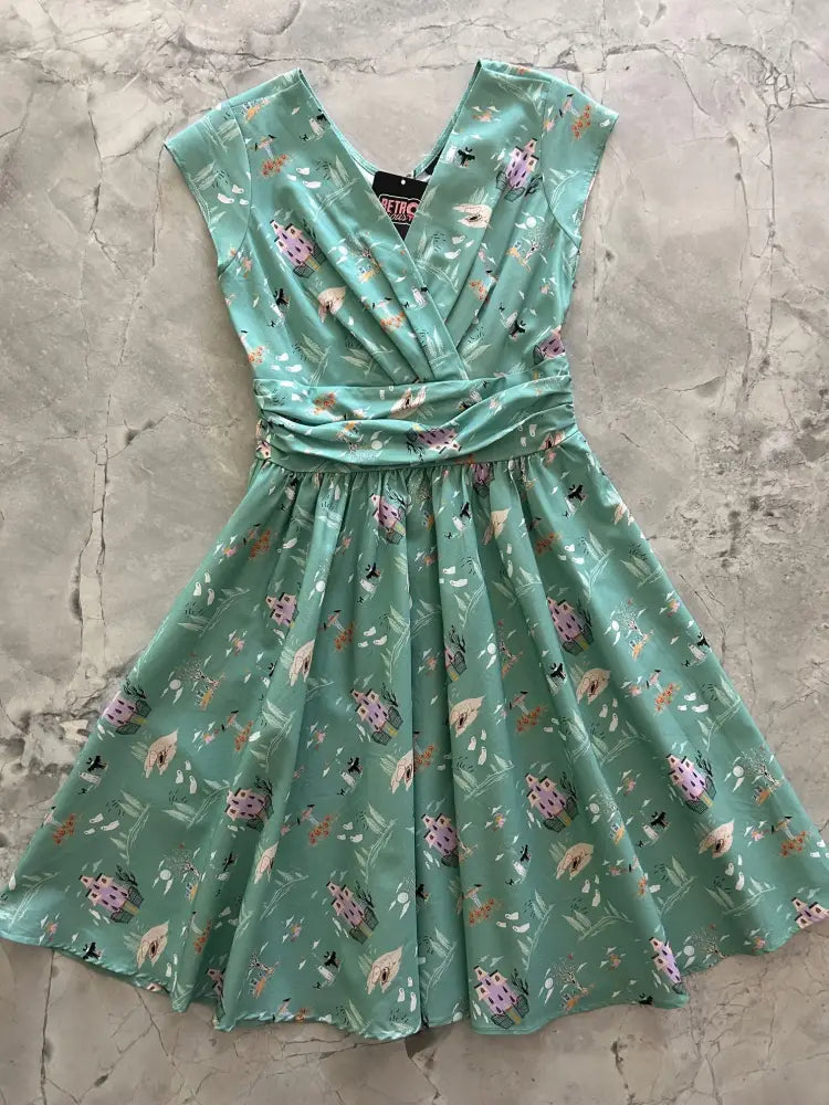 A mint green cotton vintage flare dress with v-neckline and whimsical pink house pattern for Halloween