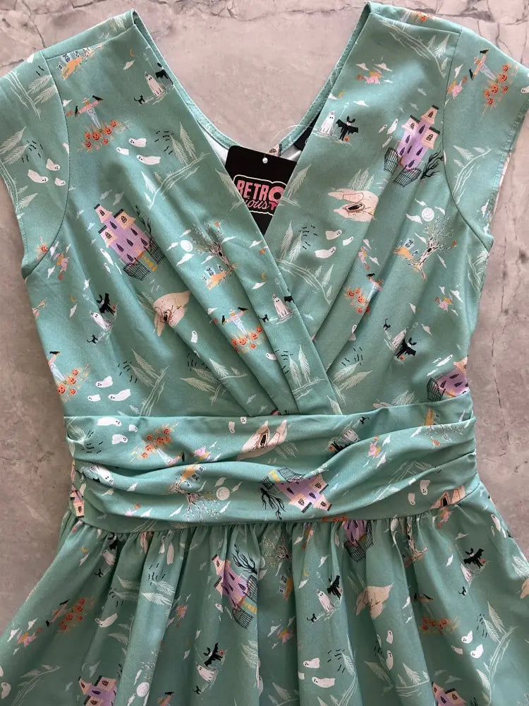 A mint green sleeveless Greta Spooky Fun Halloween teal cotton vintage flare dress with a gathered waist and whimsical print