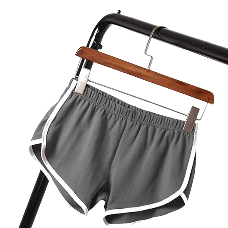 Gray sports shorts women with elastic waist and white trim hanging on wooden hanger for casual athletic use