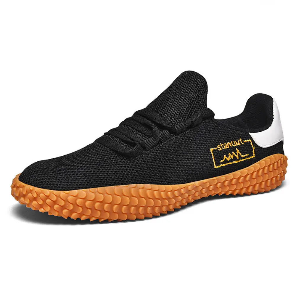 Men’s breathable flying woven mesh Korean sneaker in black with textured orange sole and gold embroidered branding