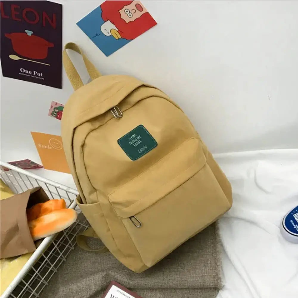 Beige canvas women’s Korean corduroy pastel school and travel backpack with a green rectangular patch on the front