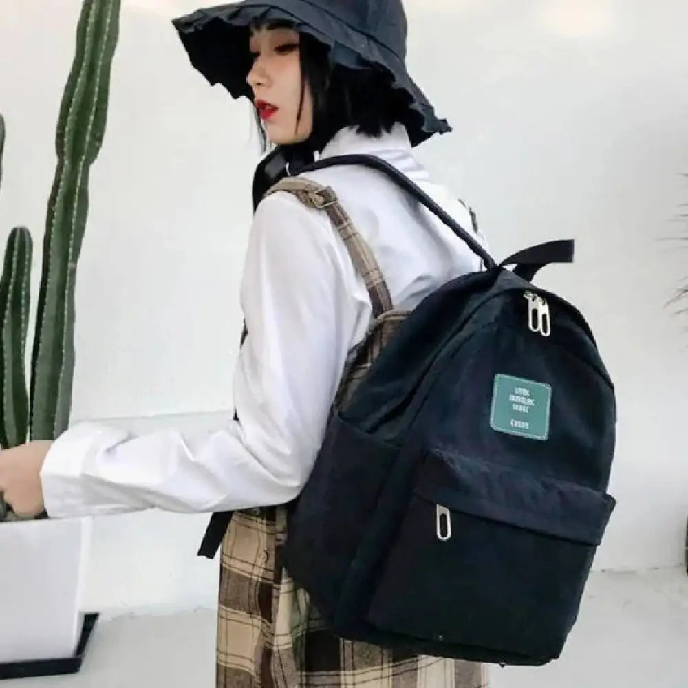 Women’s Korean corduroy pastel school and travel backpack black canvas with green patch and silver zippers front view