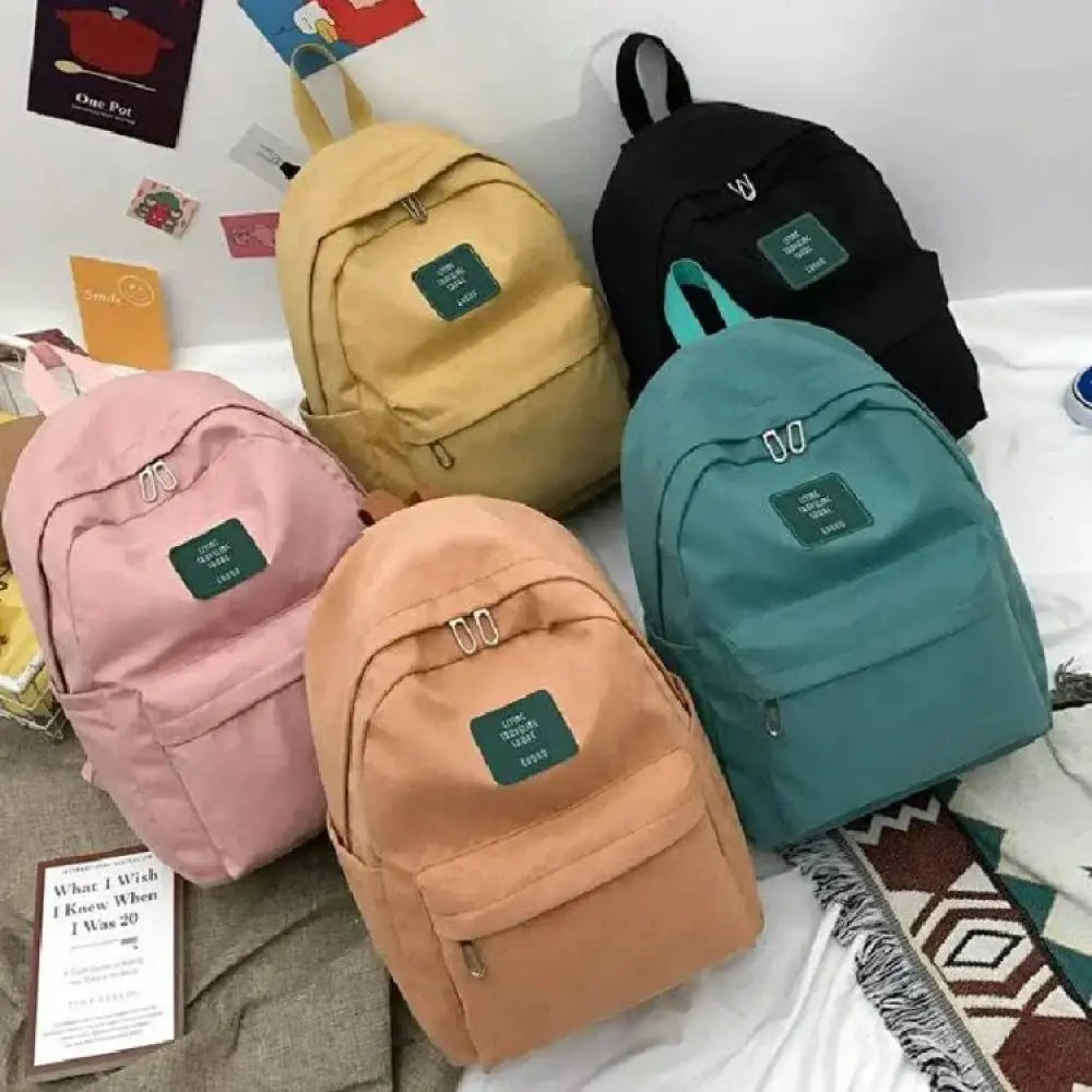 A collection of women’s korean corduroy pastel school and travel backpacks with green patches and metallic zippers