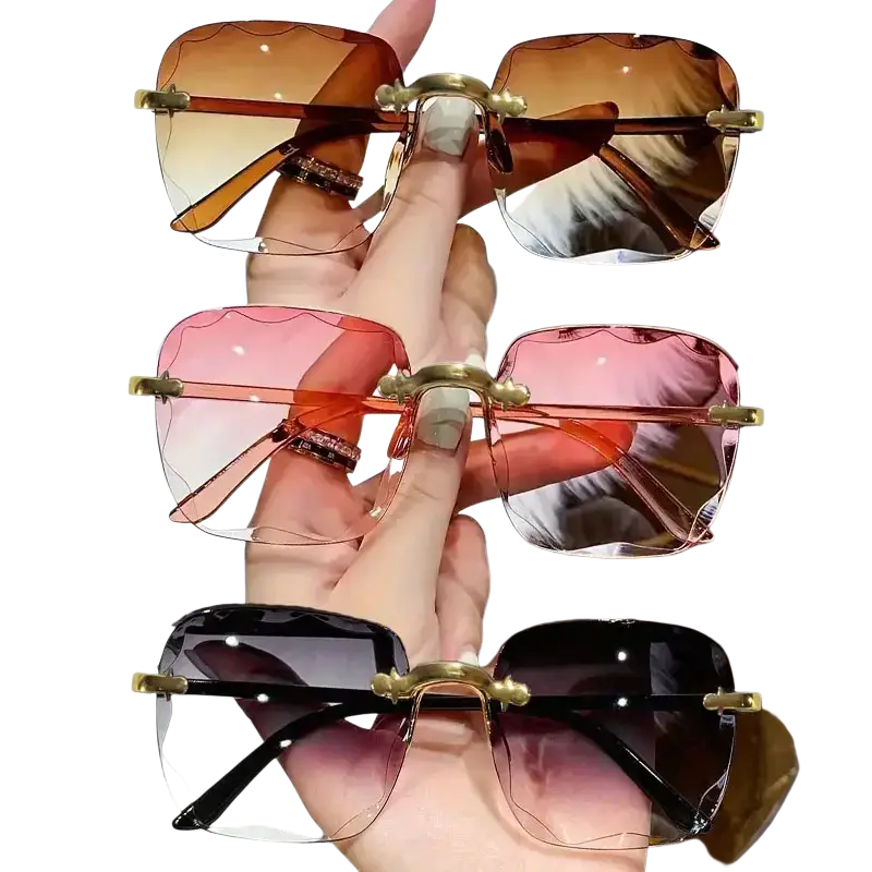 A hand holds three pairs of square gradient sunglasses for women in brown lenses and gold metal frames