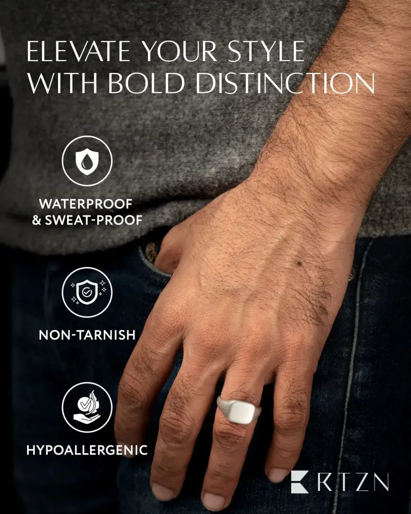 A sleek oxidized silver square signet ring in stainless steel with a smooth rectangular face worn on the ring finger