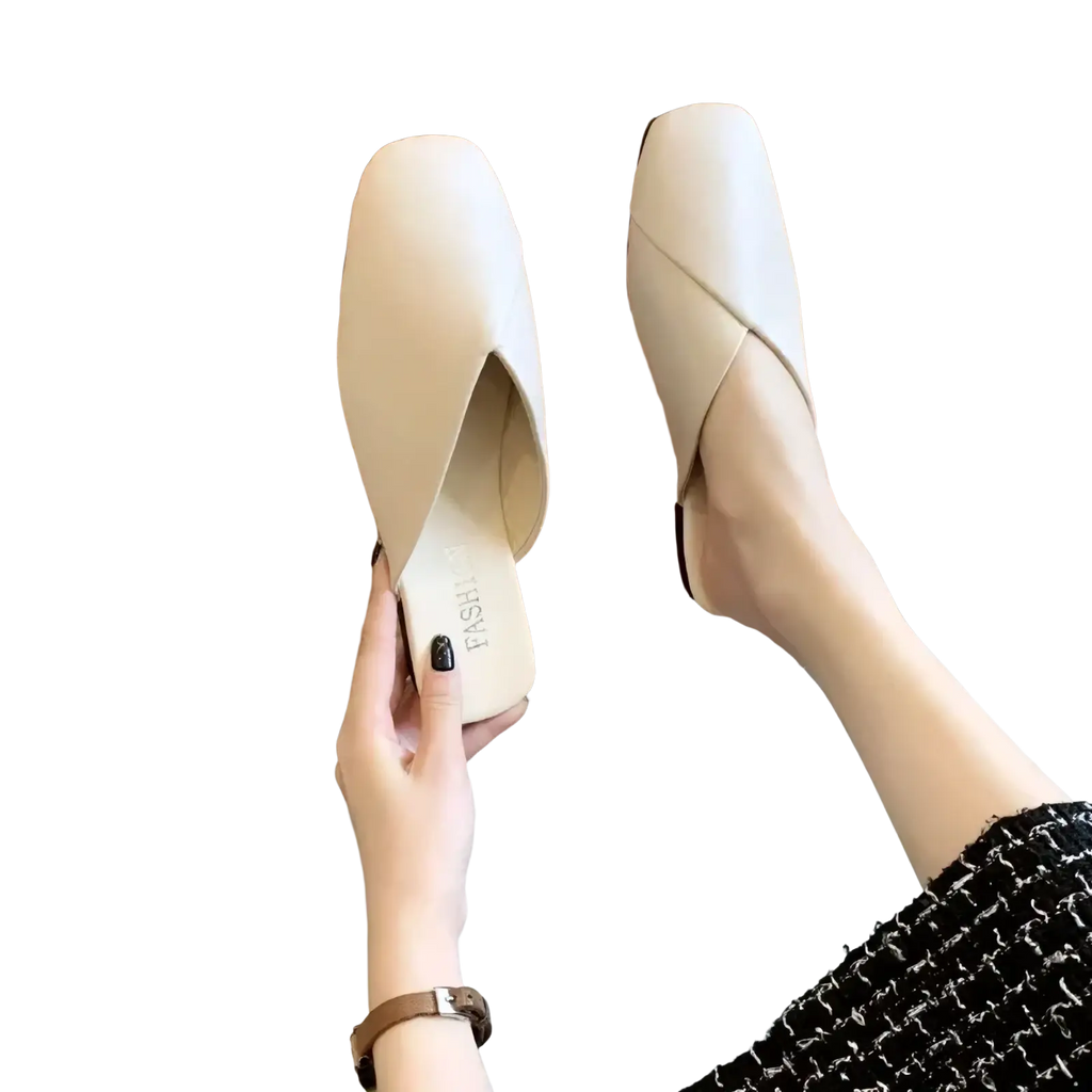 Cream-colored square toe flat leather mules featuring a sleek minimalist design and soft leather upper