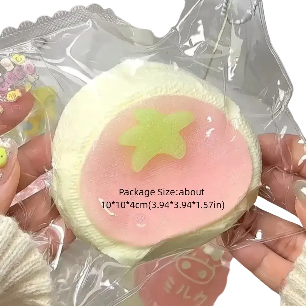 A soft, round squeeze toy with a pale yellow outer layer and pink center featuring a glowing green star for stress relief
