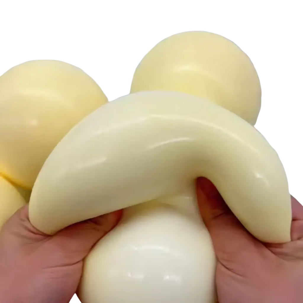 Cream-colored glossy silicone squishy ball with a curved banana shape for stress relief and sensory use