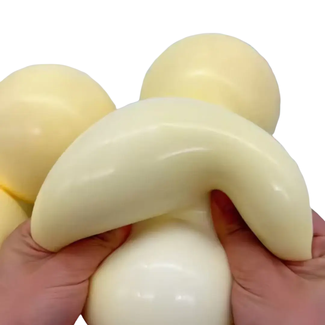 Cream-colored glossy silicone squishy ball with a curved banana shape for stress relief and sensory use