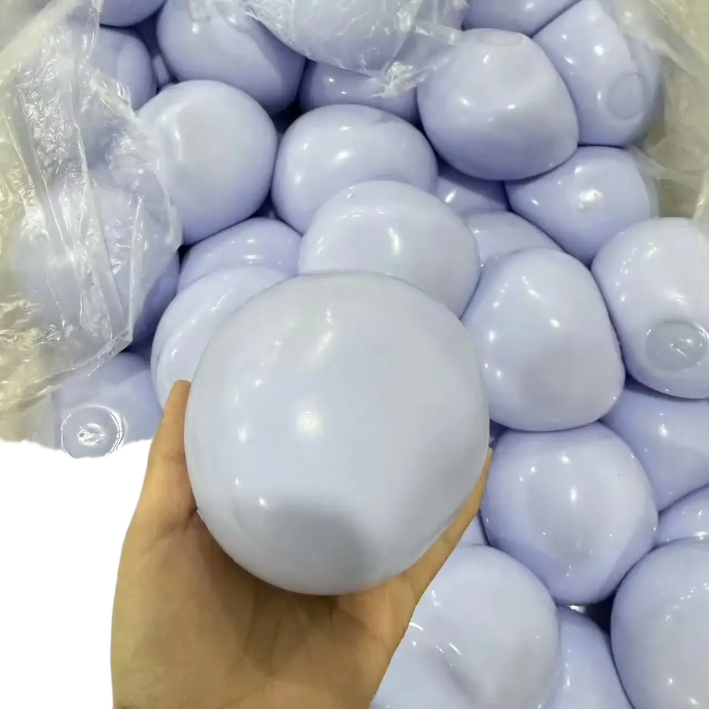 A hand holds a smooth light purple plastic squishy ball stress relief sensory toy for calming and focus