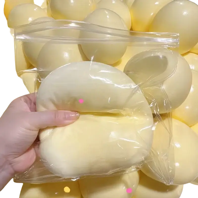 A pale yellow silicone squishy ball stress relief toy with a smooth, glossy surface and rounded elongated shape