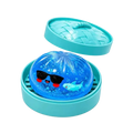 A translucent blue gel-filled squishy dumpling stress ball with a cartoon shark and sunglasses in a turquoise woven container finished goods