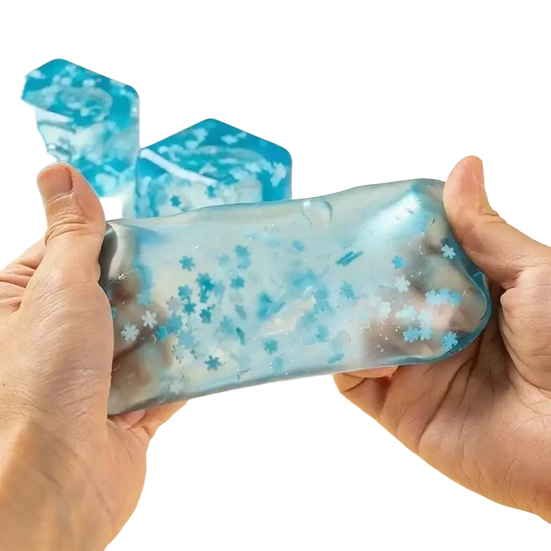 Hands holding blue translucent squishy snowflake ice cubes gel with embedded snowflake particles sensory toy