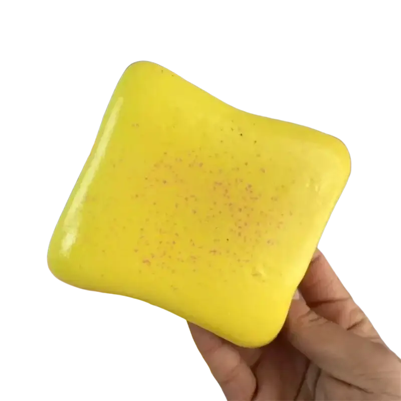 Bright yellow squishy toast stress relief toy with glossy finish and subtle speckled texture in macaron color