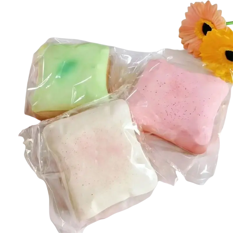 Three pastel-colored macaron squishy toast stress relief toys in clear plastic packaging made of soft material