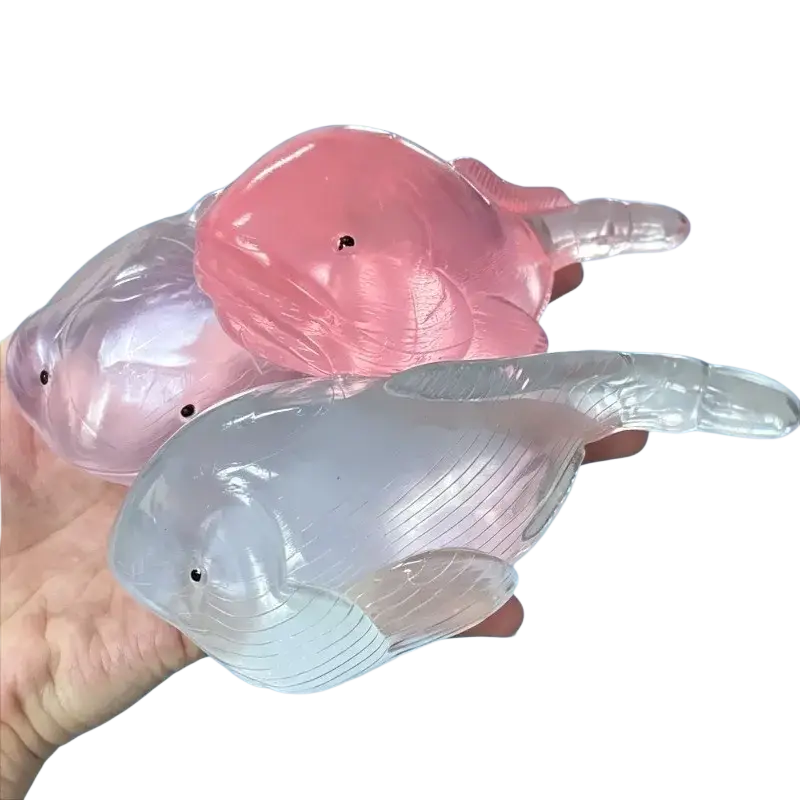 Squishy whale fidget toy stress ball set featuring pink and clear silicone whales with black dot eyes for stress relief
