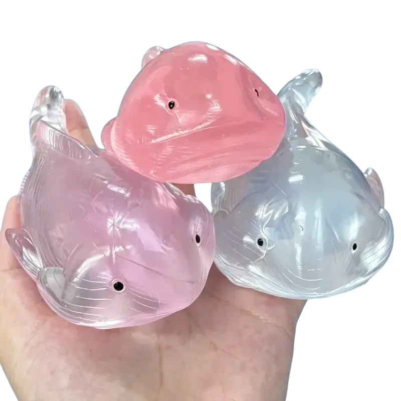 Squishy whale fidget toy stress ball set featuring three translucent pink and clear squishy whale shapes with black eyes
