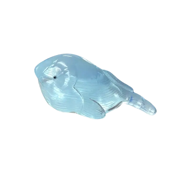 A translucent light blue whale-shaped squishy fidget toy with ridged fins and a glossy finish stress ball
