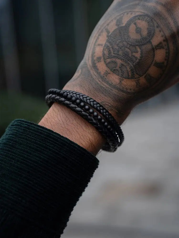 Black braided leather bracelet with textured woven design and stacked black onyx stainless steel accents