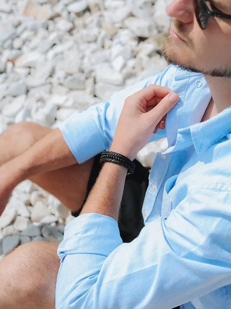 Black braided leather stainless steel bracelet with stacked black onyx worn on a mans wrist