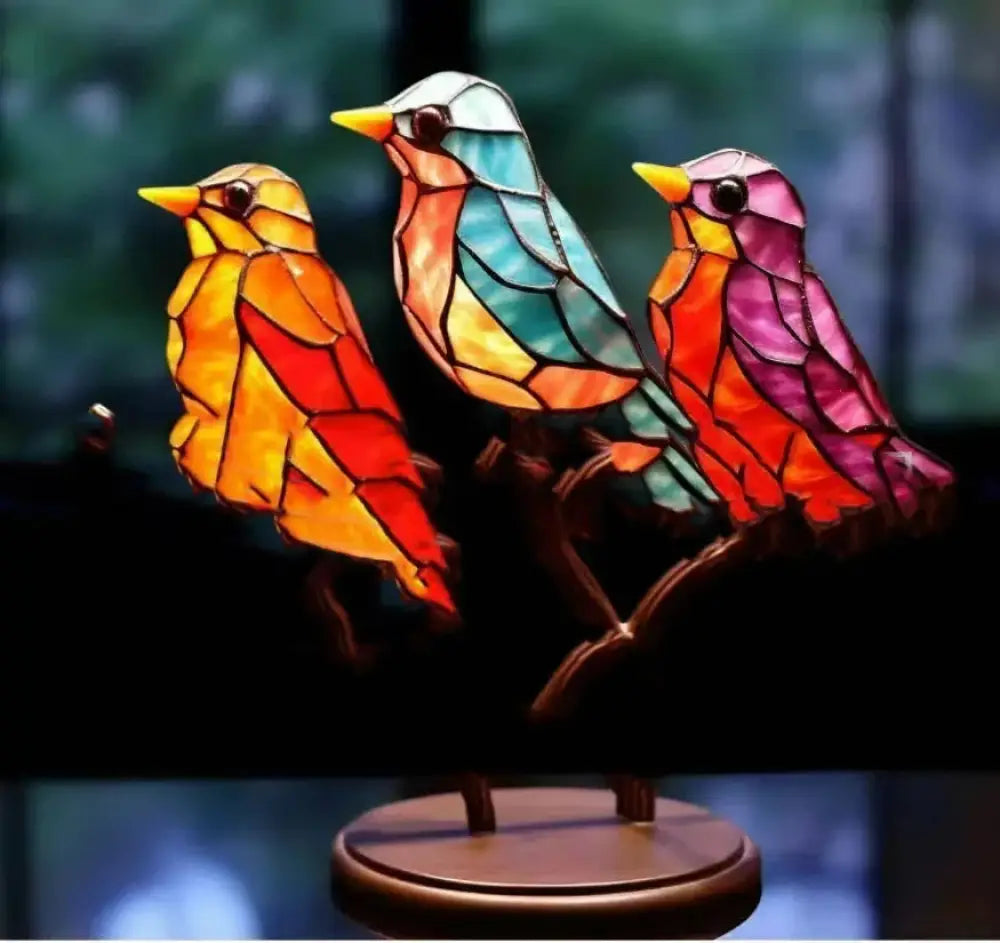Vibrant stained glass bird lamp with three colorful orange teal and pink geometric birds on dark wooden branch base