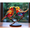 Vibrant stained glass birds figurine with red orange yellow blue and purple mosaic perched on ornate bronze branch