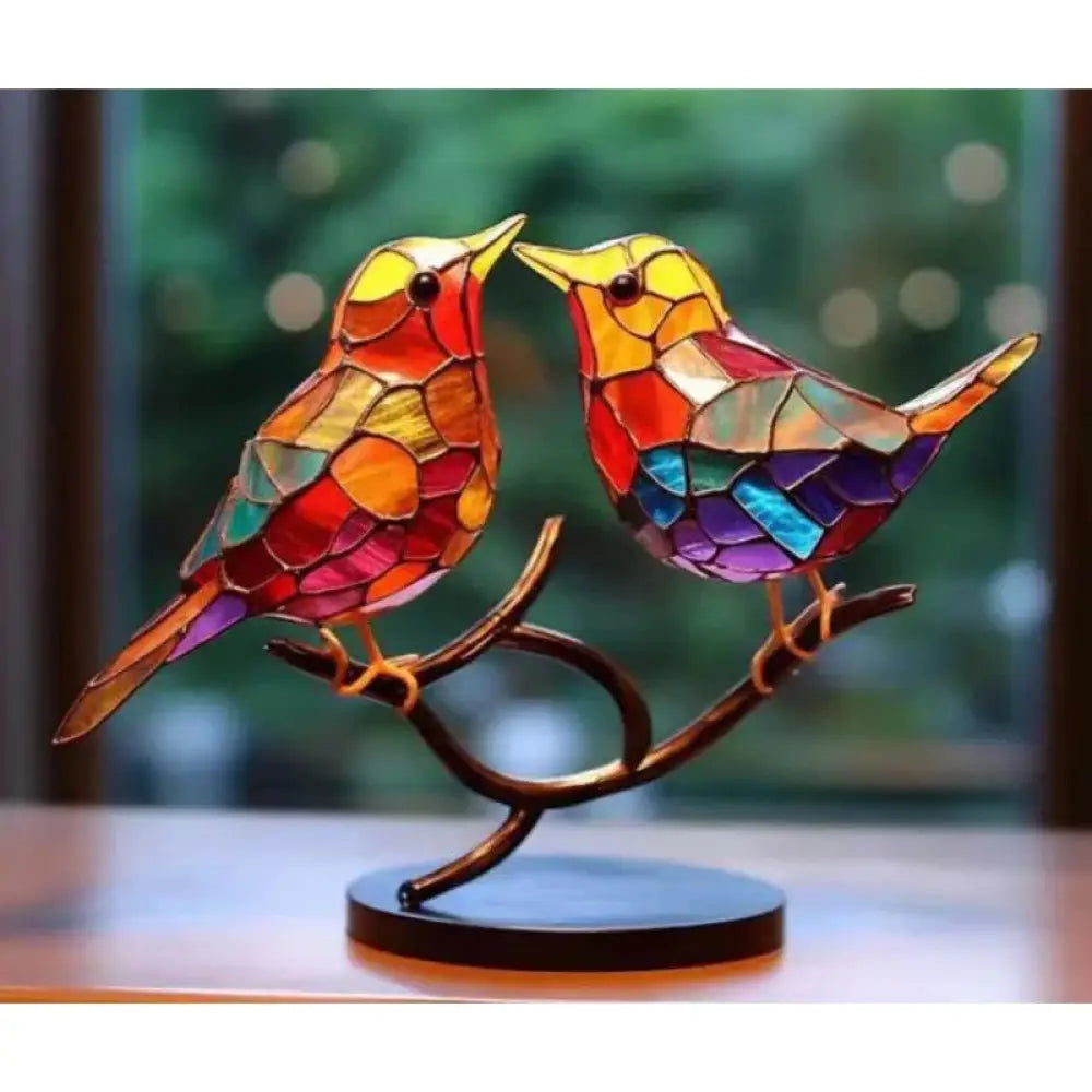 Vibrant stained glass birds figurine with red orange yellow blue and purple mosaic perched on ornate bronze branch