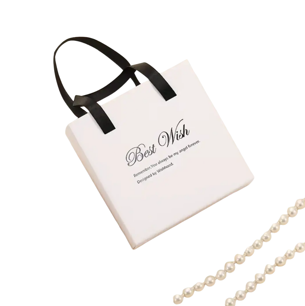 White gift box with black ribbon handles and best wish text containing stainless steel just breathe anxiety wrap ring inside