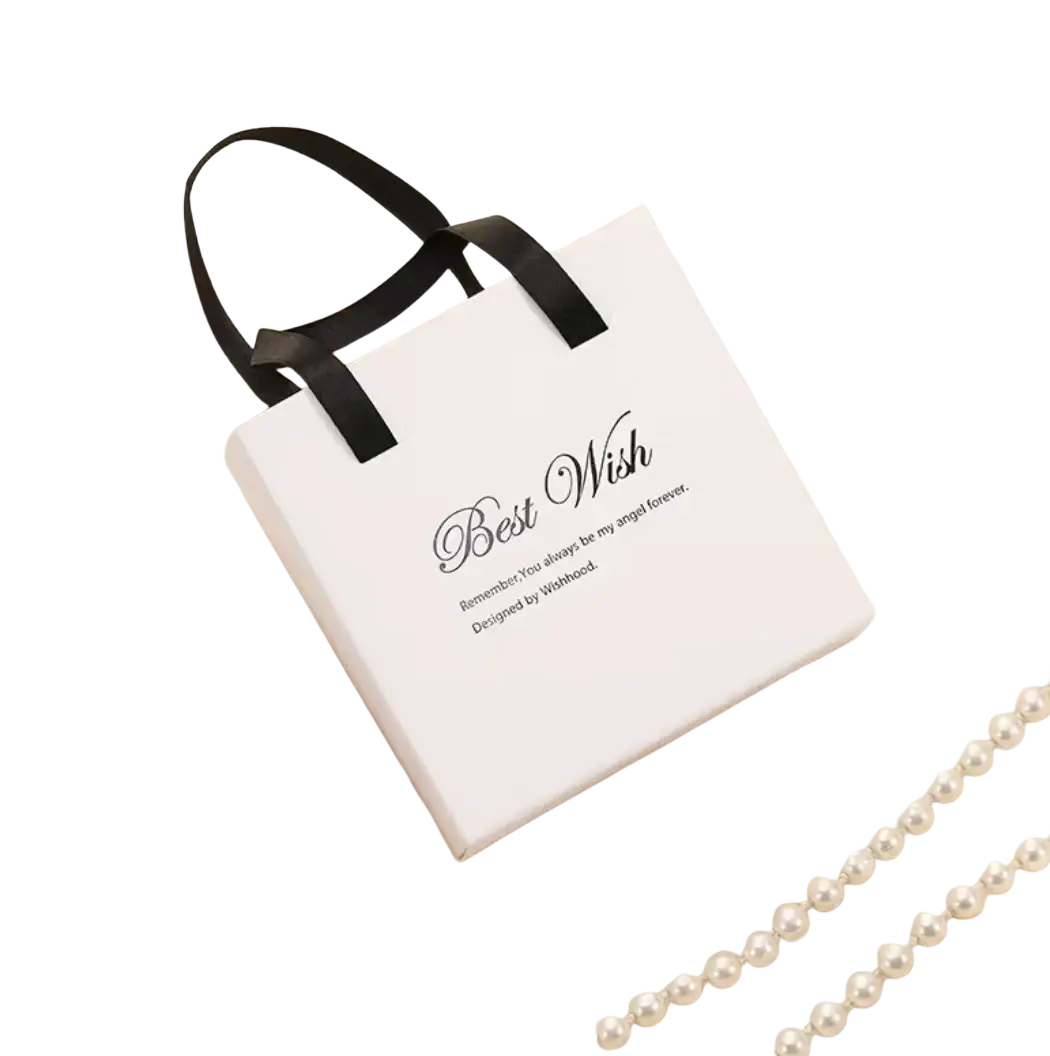 White gift box with black ribbon handles and best wish text containing stainless steel just breathe anxiety wrap ring inside