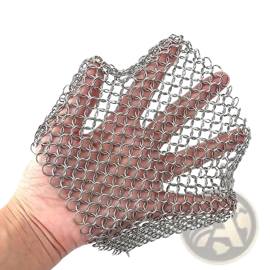 A hand holds a flexible silver stainless steel chainmail glove for cleaning cast iron pots