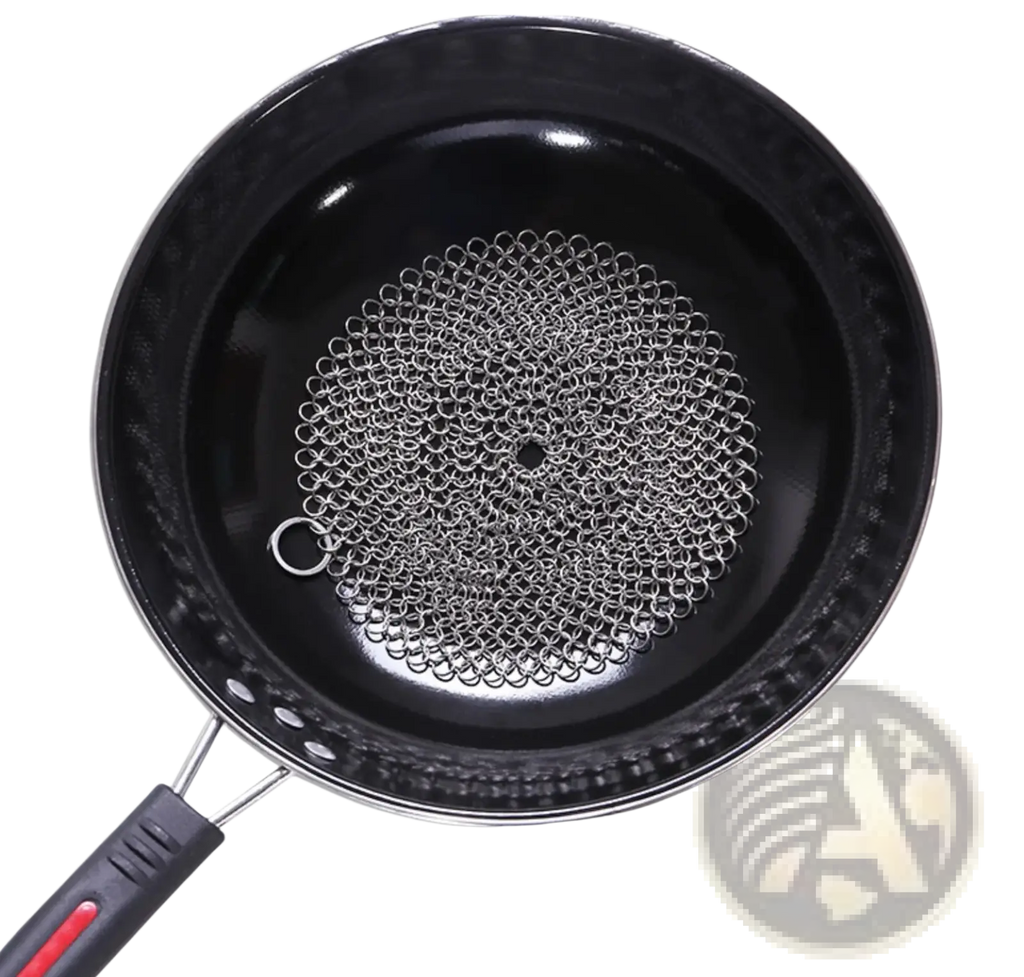 Black nonstick frying pan with stainless steel silver chainmail cast iron scrubber resting inside