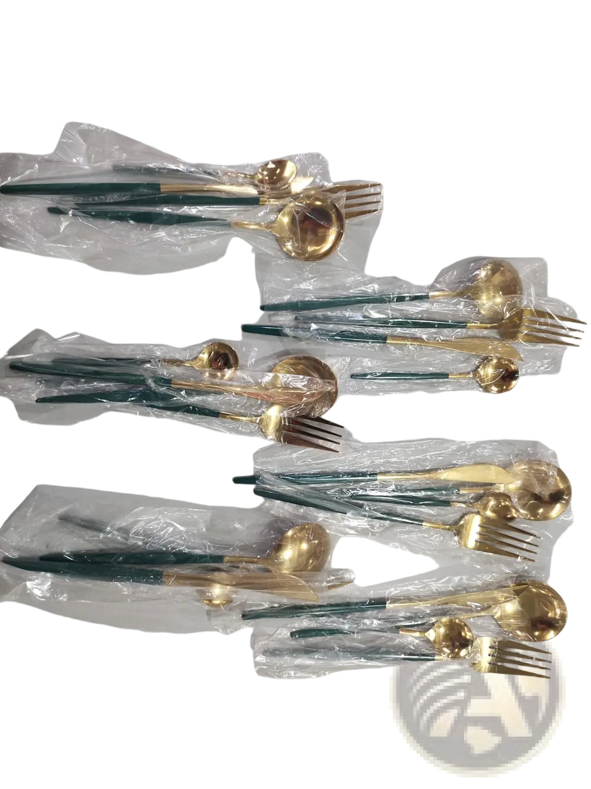 Set of stainless steel cutlery with elegant gold-toned blades and dark green handles neatly packaged in clear plastic