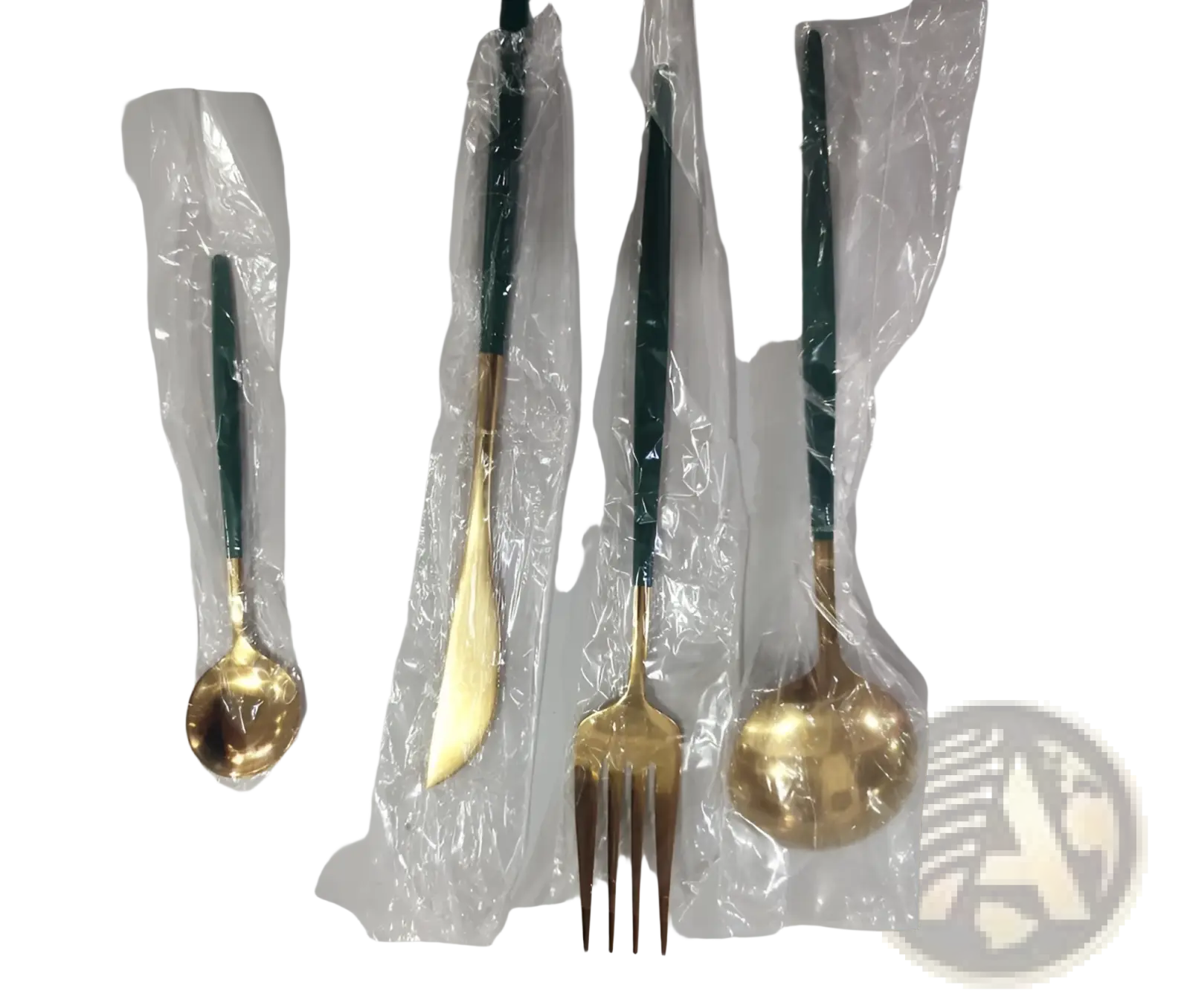 Set of four stainless steel cutlery pieces with gold tones and dark green handles individually wrapped in clear plastic