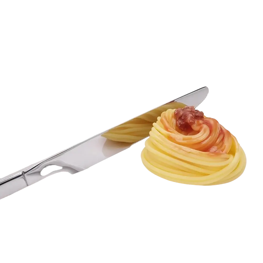 Shiny stainless steel butter knife with mirror finish resting beside an artfully arranged pasta dish in cutlery set