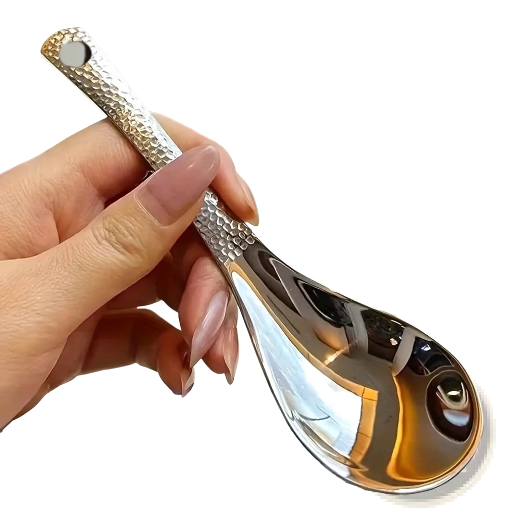 A sleek hammered silver stainless steel dessert spoon with a reflective bowl and textured handle