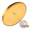 A sleek, oval-shaped gold-colored stainless steel dinner plate with smooth reflective surface and raised edges