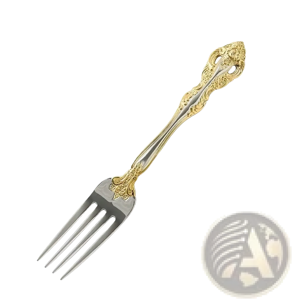 Ornate stainless steel flatware fork with gold inlaid accents and intricate floral detailing on the handle
