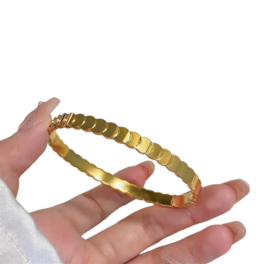 A sleek gold-toned stainless steel bangle bracelet for women with polished rounded segments and scalloped edges